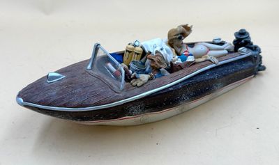 a figurine of a man and a dog riding in a boat