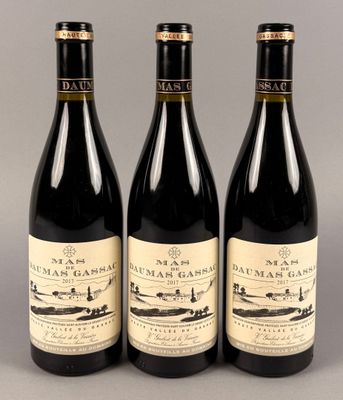 trois bouteilles de vin sont alignées sur une table