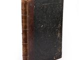 an old book that is sitting on a white surface