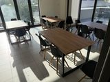 des tables et des chaises dans une pièce dotée de grandes fenêtres et offrant une vue sur la ville