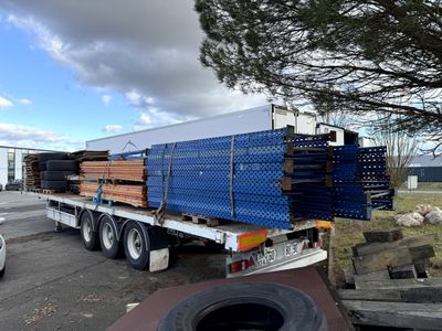 un camion dont la benne est chargée d'une grande quantité de bois
