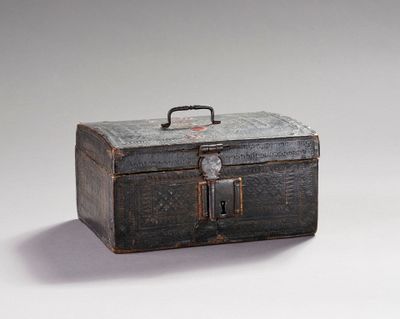 une petite boîte en métal munie d'une poignée, posée sur une surface blanche