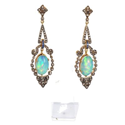 une photo d'une paire de boucles d'oreilles en oplite et en diamant