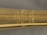 an image of a close up of a gold flute with a label on it