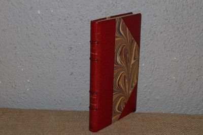 a small red book with a gold design on it