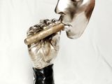 statue d'un homme avec une cigarette à la bouche et un masque sur la tête