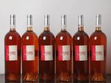 six bouteilles de vin sont alignées sur une table en bois
