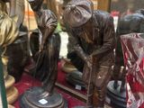 une vitrine sur laquelle sont posées deux figurines en bronze