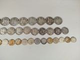 several different types of coins are arranged in a row on a white surface