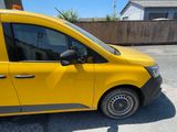 the yellow van is parked in the parking lot next to the building