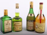 trois bouteilles d'alcool sont alignées sur une surface blanche