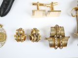many different types of gold jewelry on a white surface
