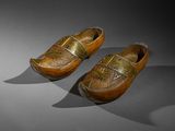 pair of wooden clogs with gold decoration on them
