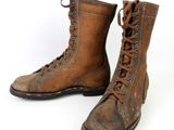 pair of brown leather boots with laces on them on a white background