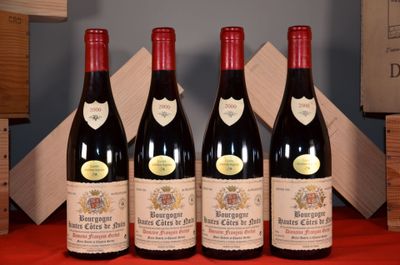 three bottles of red wine are lined up on a red table