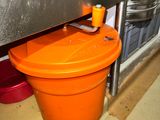 an orange bucket that is sitting on the floor