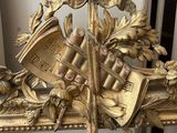 a gold frame with a clock on it on a table