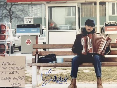 un homme assis sur un banc avec un accordéon
