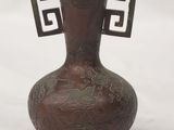 a brown vase with a design on it on a white surface