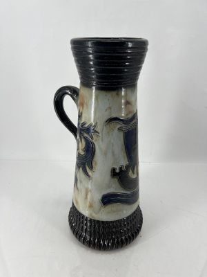 un vase noir et blanc sur lequel est représenté un visage