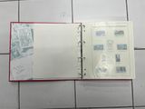 an open book with stamps on it on a tiled floor