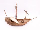 a model of a wooden boat on a white surface