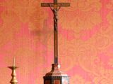 une croix posée sur une commode, avec une bougie