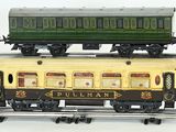 two train cars on the tracks with a green and yellow one