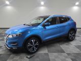 un SUV Nissan bleu garé sur un sol en carrelage à damier