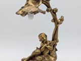 a brass plated lamp with a bird and flower on it