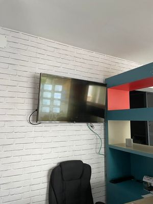 un bureau avec une chaise et une télévision fixée au mur
