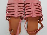 a pair of pink sandals on top of a white box