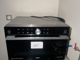 a silver microwave sitting on top of a stainless steel refrigerator