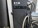 a black electric charger sitting on a desk next to a computer