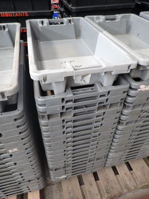 de nombreux conteneurs en plastique empilés sur une palette dans un entrepôt