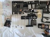 a lot of jewelry on a bed with a white sheet