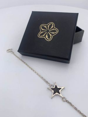 a black box with a silver star charm and a black box with a gold star charm