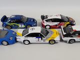 several toy cars are lined up in a row on a white surface