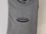 a close up of a gray shirt with a blue logo on it