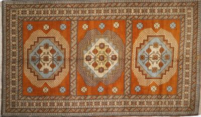 an orange and blue rug with four medallions on it