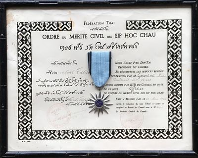 certificat encadré, orné d'un ruban bleu et d'une étoile, dans un cadre noir et blanc