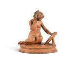 statue représentant une femme assise sur un tabouret, les jambes croisées