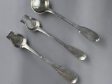 three spoons and a spoon rest on a gray surface