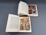 un livre ouvert posé sur une table à côté d'un livre ouvert