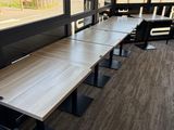 une longue table avec des chaises devant une fenêtre