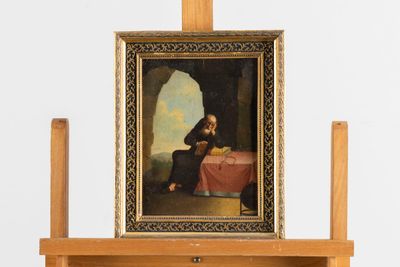 une photo d'un tableau posé sur un chevalet, sur lequel figure le portrait d'un homme