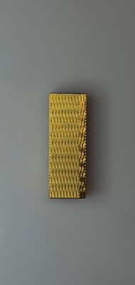 a yellow brush on a gray surface next to a gray wall