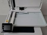 an open printer sitting on top of a white table next to a cell phone