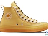 a close up of a pair of yellow converses on a white background