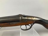 an old gun with a wooden handle on display in a glass case